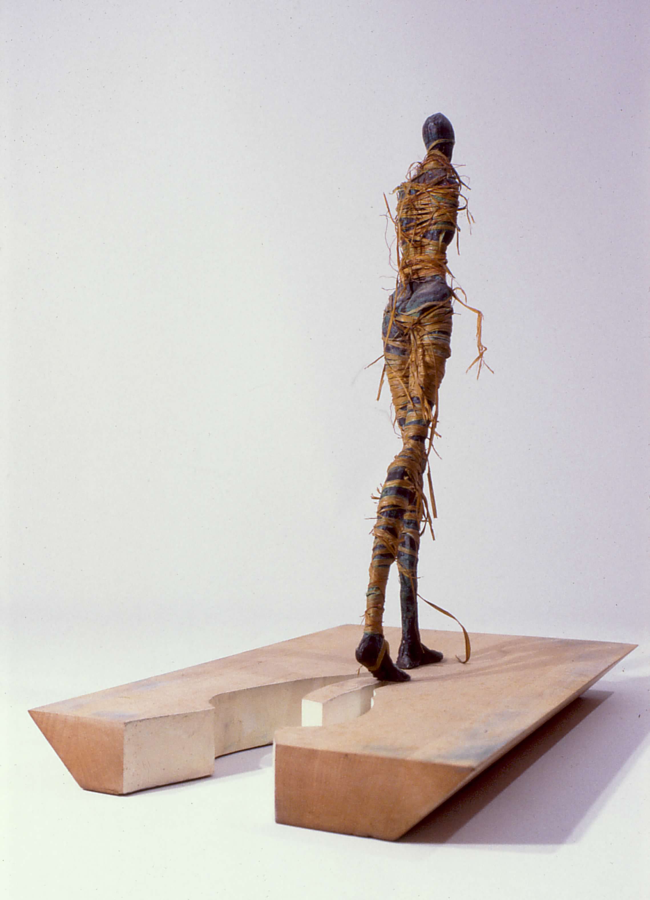 Bronze, wood, raffia and thread. last revision 1990, 16" x 10" x 17". I tinkered with this piece through several showings before boxing up all my bronzes and turning my attention to drawing. After my son started kindergarten, I pulled the boxes off the shelf. It was an amazing period of clarity. I made my peace with the way I made sculpture and, one by one, began to rediscover, reclaim each figure, each sculpture. The years of storage in an unheated shed had taken its toll on In Between. The raffia was in tatters, and in the places where it had broken or slumped, patina stripes could be seen, cris-crossing the figure, echoing the original taunt bindings. I kept putting off a planned re-wrap and then I understood. Change is inevitable. Families, jobs and living arrangements continually evolve. Sometimes I readily shuck the confines of the old, eager to explore the new. But some transitions are hard, forced, painful. Going back is not an option; going forward seems impossible. I am trapped in a backwater, an in between, by my pride, my fear of starting over, my refusal to trade in old hopes and dreams. In Between went into storage tightly bound; it came out marked by the experience, but its bindings were falling away, disintegrating. In Between isn’t a moment in time, it is a process. It takes time to grieve losses, to accept and welcome new possibilities. It takes time for wounds to scab over, heal and scar. But eventually I am ready - to sail on, to chart a new course, to learn a new way of being.